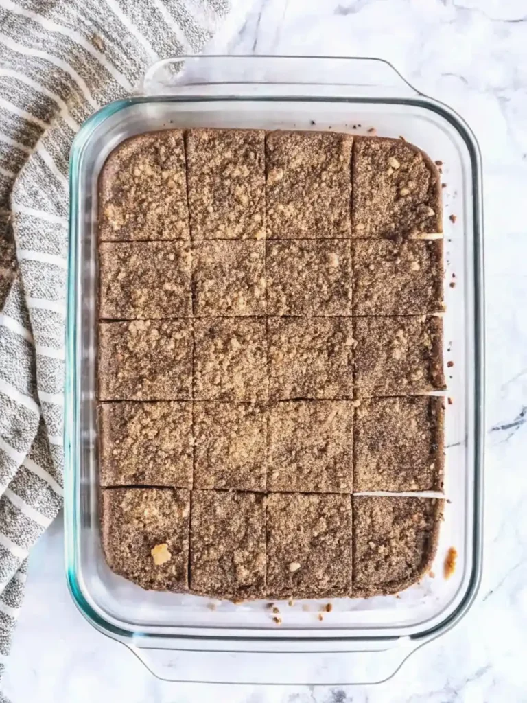 Overhead view of Disneyland Peanut Butter Squares freshly sliced in a glass baking dish, showing a crumbly top layer.