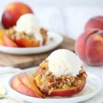 Baked stuffed peaches with streusel and topped with a scoop of ice cream.