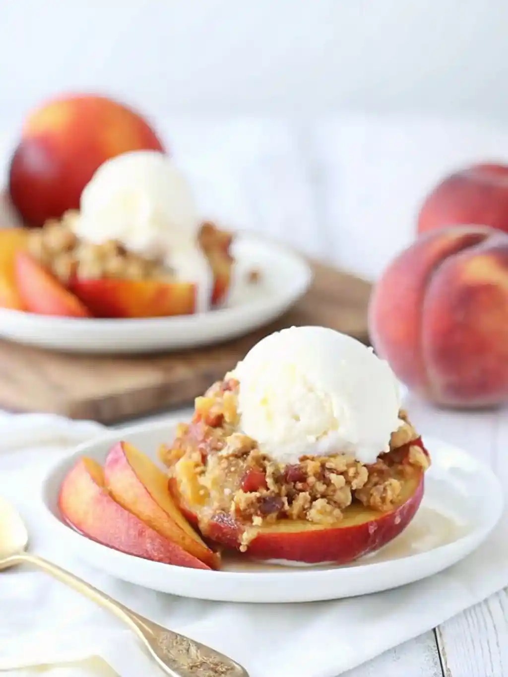 Baked stuffed peaches with streusel and topped with a scoop of ice cream.
