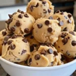 Frozen Greek Yogurt Peanut Butter Bites stacked in a white bowl, topped with chocolate chips