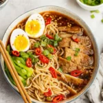 Bowl of beef ramen noodle soup recipe garnished with green onions and tender steak.