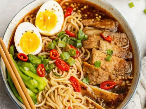Bowl of beef ramen noodle soup recipe garnished with green onions and tender steak.