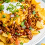 Delicious Frito Chili Pie topped with cheese and served in a skillet.