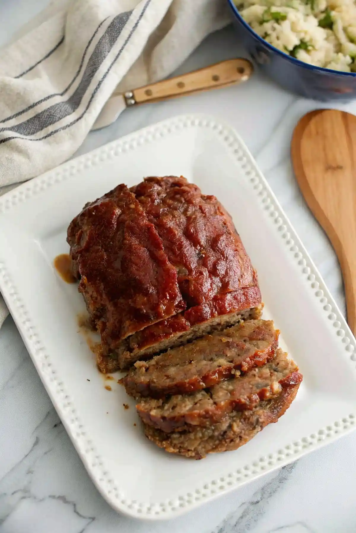 Delicious lipton's onion soup meatloaf recipe served with a side of vegetables.