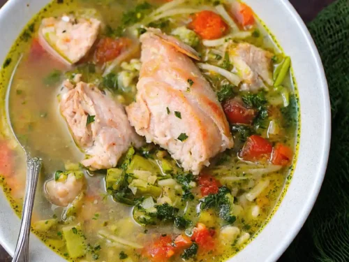 Salmon fish soup recipe in a bowl. A side of bread
