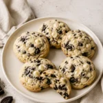 Cream-cheese cookies with chocolate sandwich-cookie pieces and white chocolate on a plate.